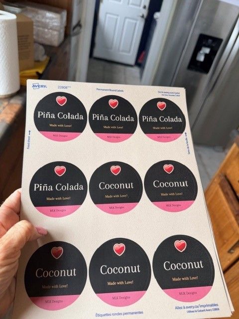 A sheet of round black and pink labels reading Pina Colada and Coconut, Made with Love